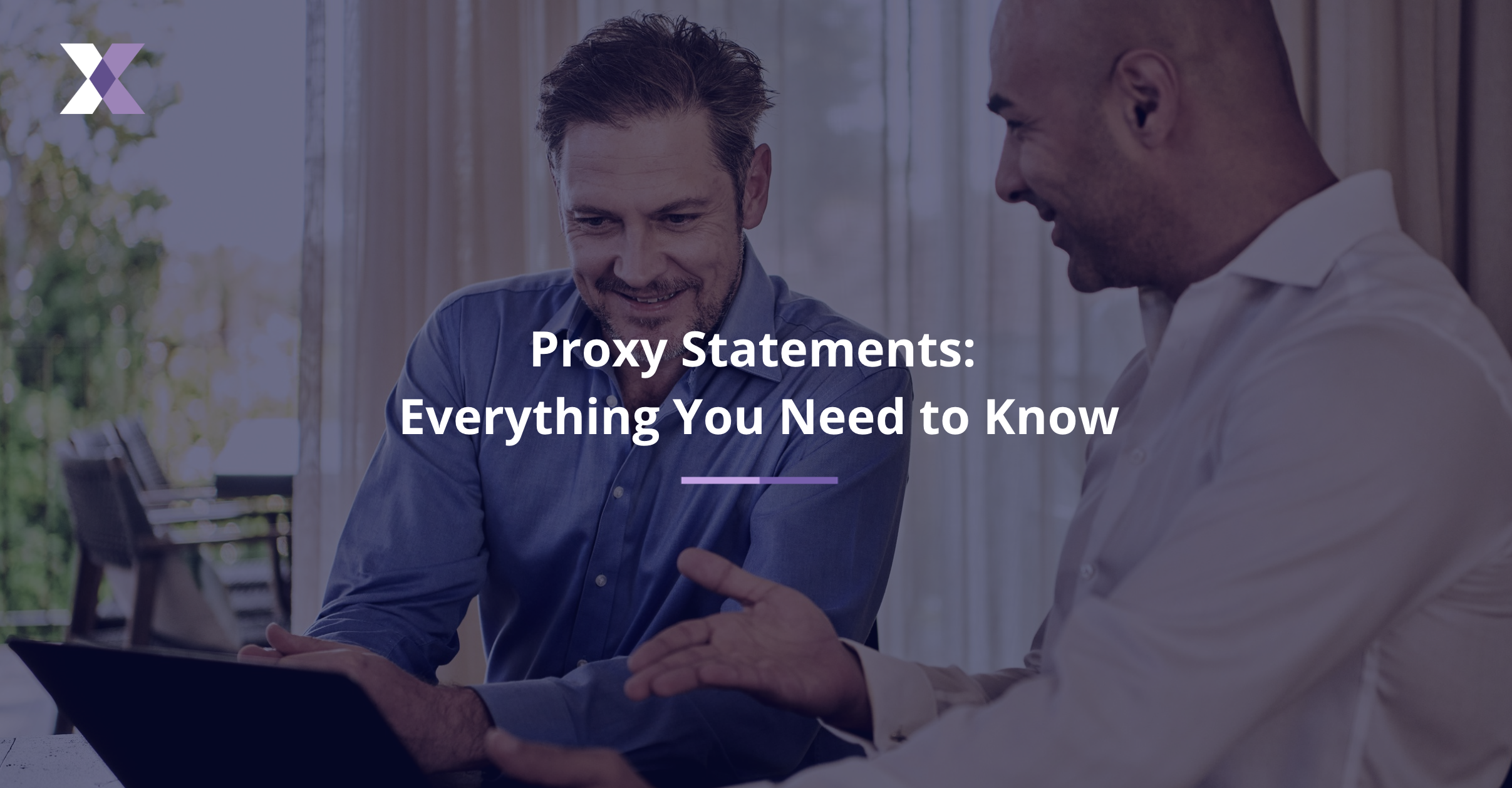 Two smiling men view a laptop screen to represent proxy statements: everything you need to know